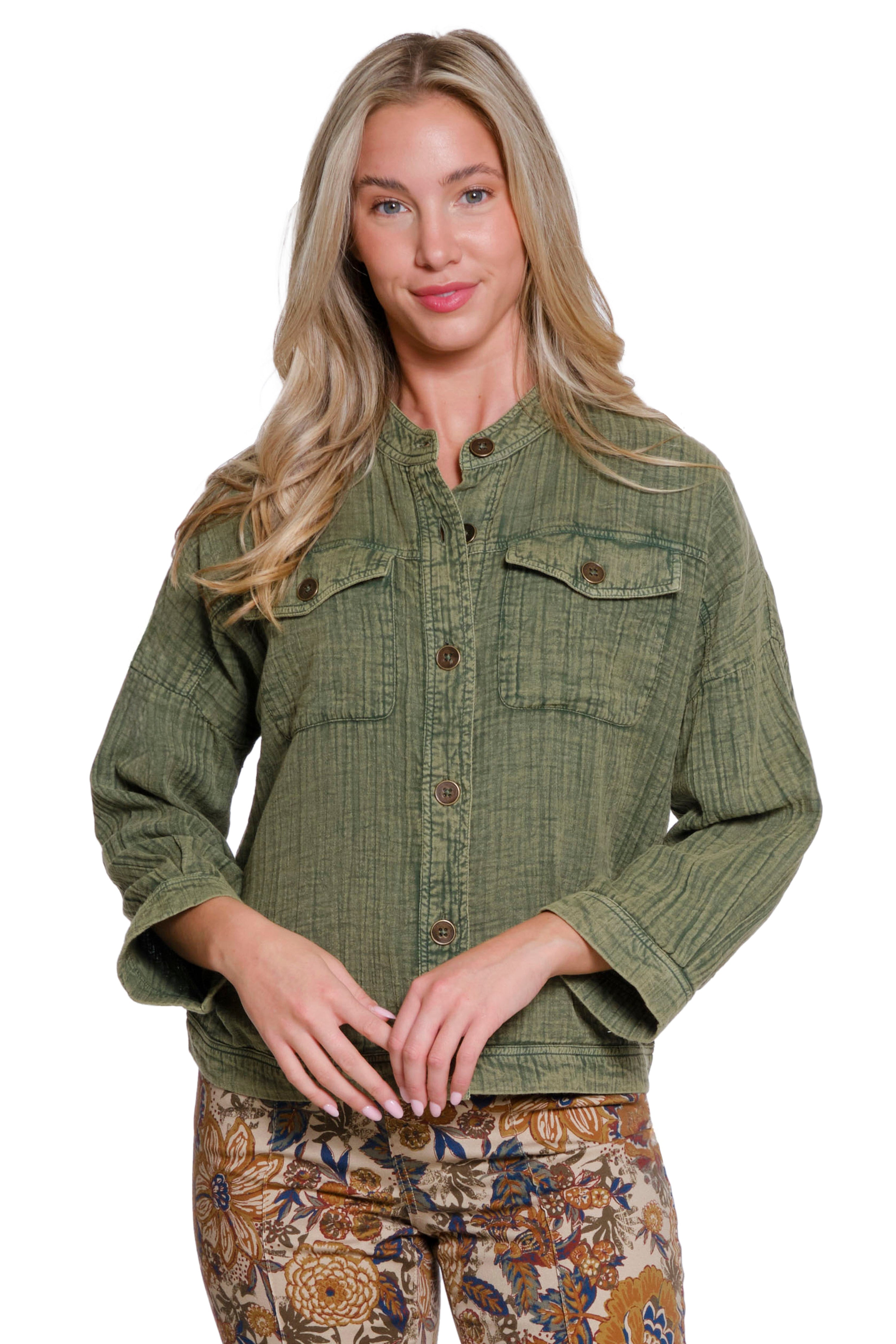 Woman wearing a green jacket with floral pants on a white background